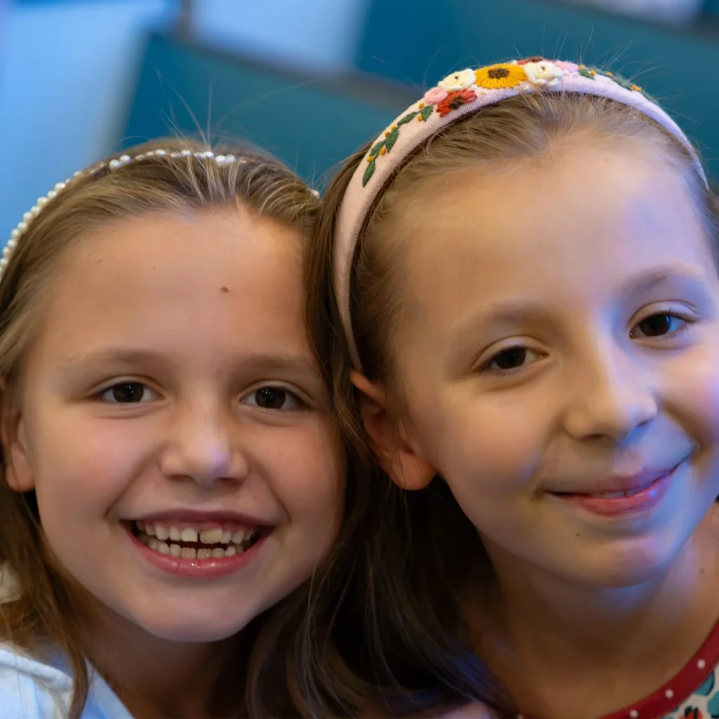 Two smiling children together inside the church